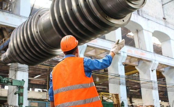 Operario tratando de reducir el polvo en la manipulación de sólidos en ingeniería.